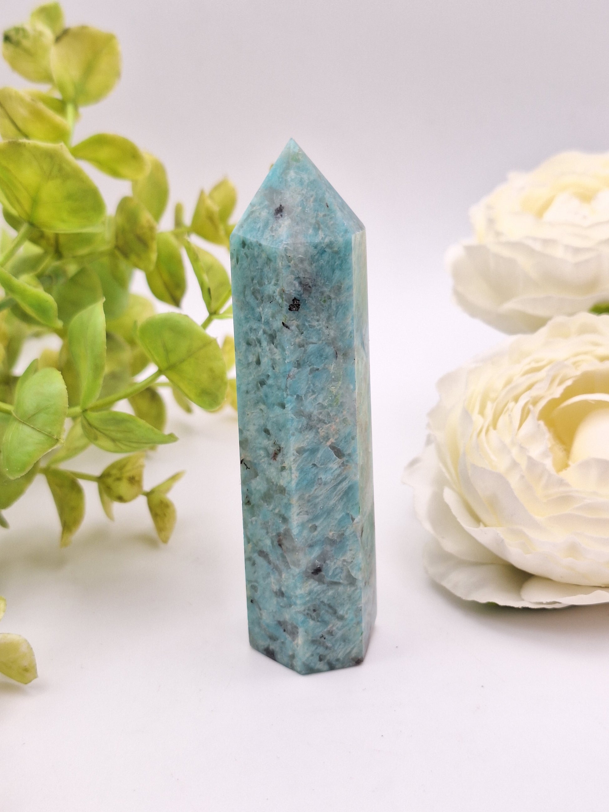 A polished Amazonite tower point standing upright, displaying its calming blue-green color and smooth finish.