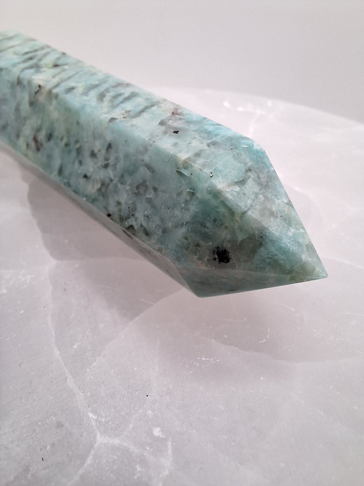 Close-up of an Amazonite tower point, highlighting its smooth polish and natural variations in soft blue-green hues.