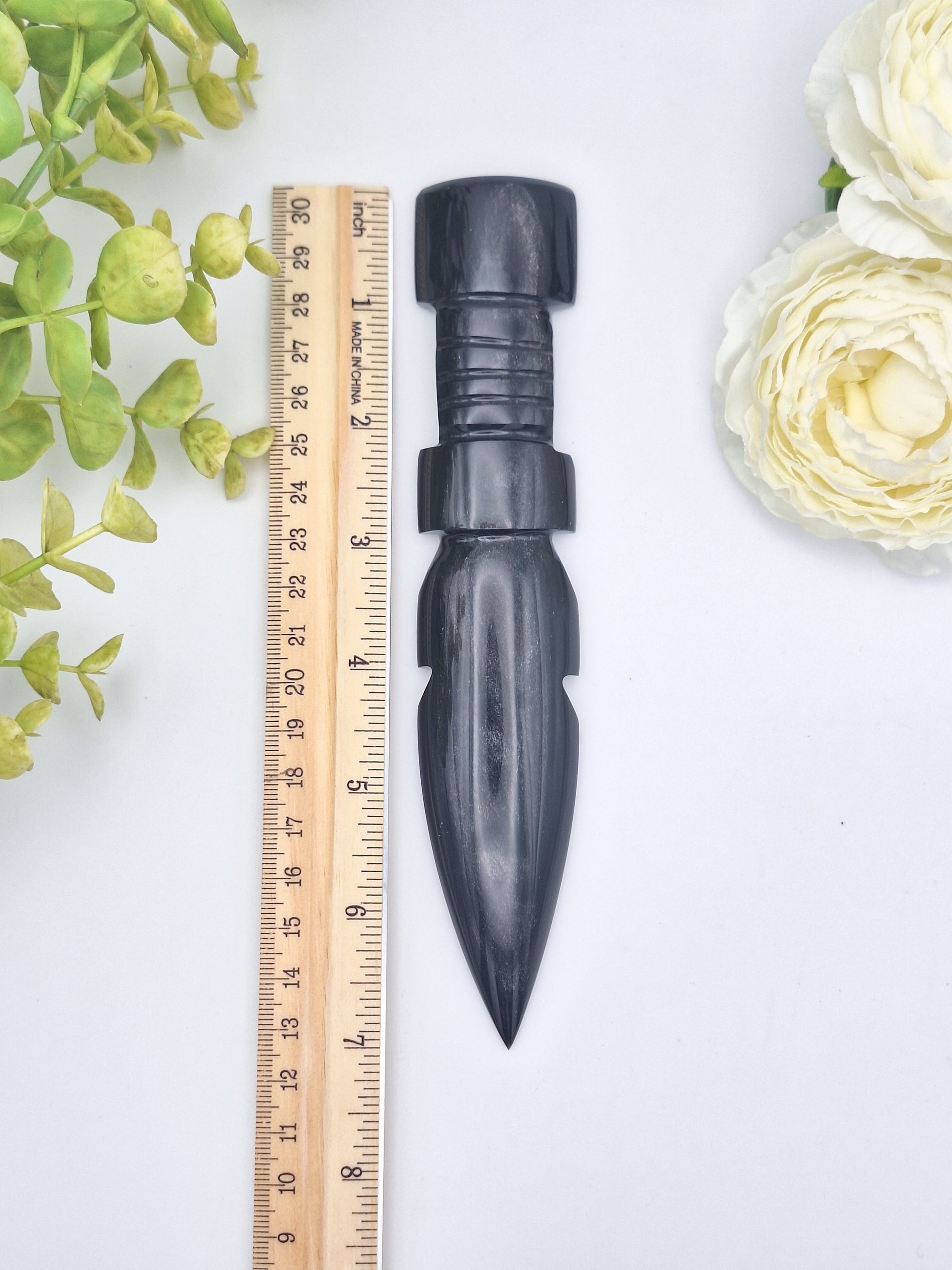 Black Obsidian carved dagger placed next to a ruler for size reference, measuring just over 7 inches in length.