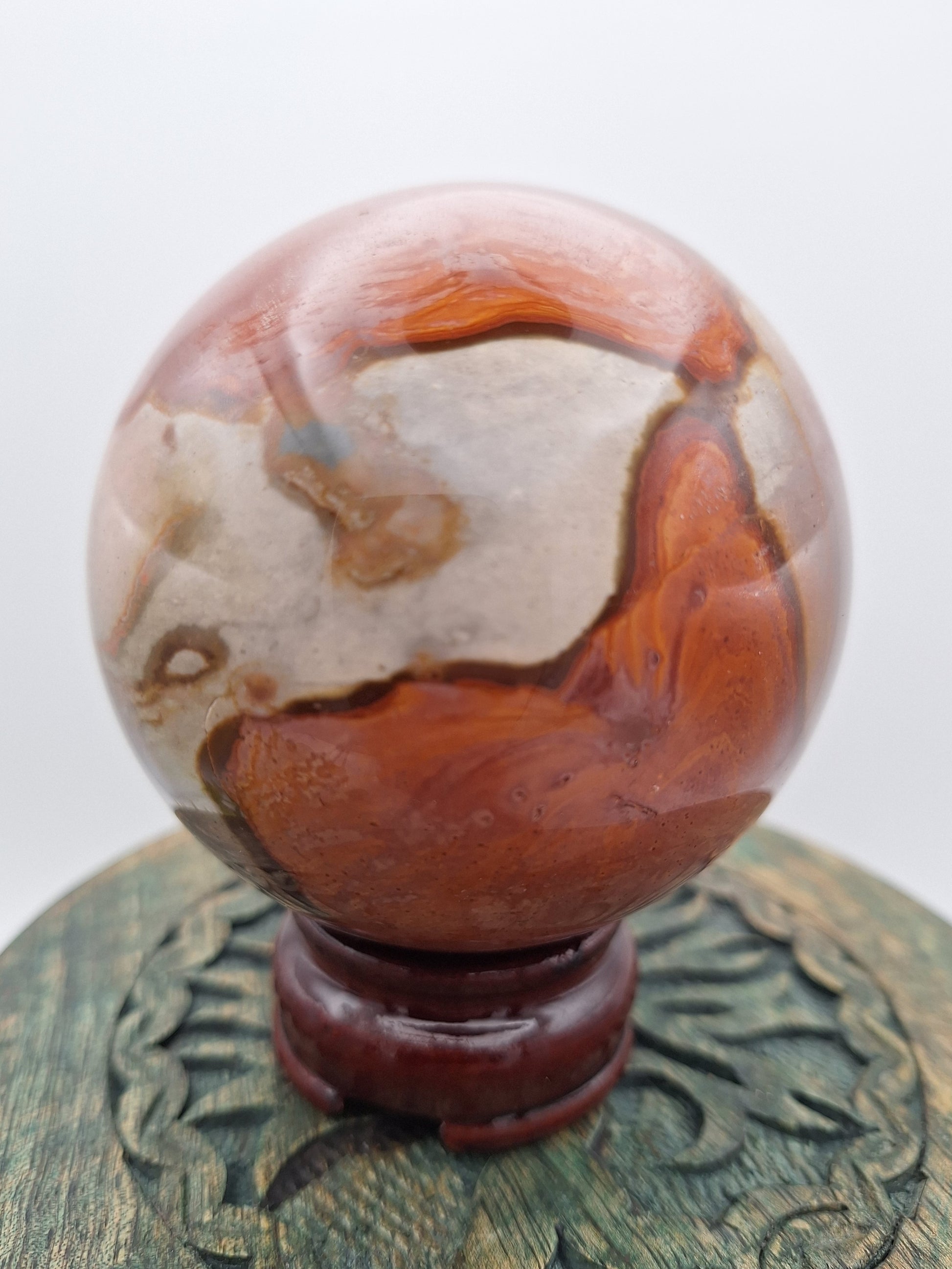 Close-up of a Polychrome Jasper sphere, highlighting its intricate color patterns and smooth, polished surface.