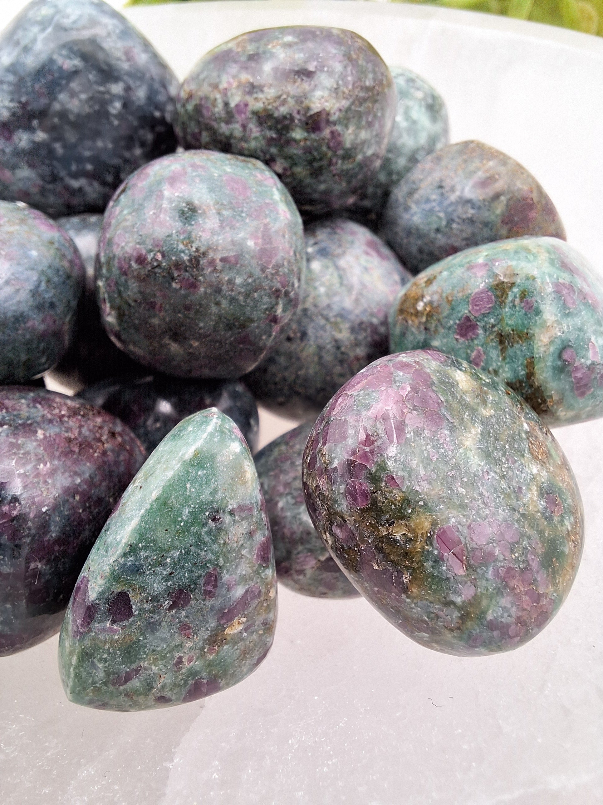 Close-up of a Ruby Kyanite tumbled stone highlighting its deep blue Kyanite base with vibrant red Ruby inclusions.