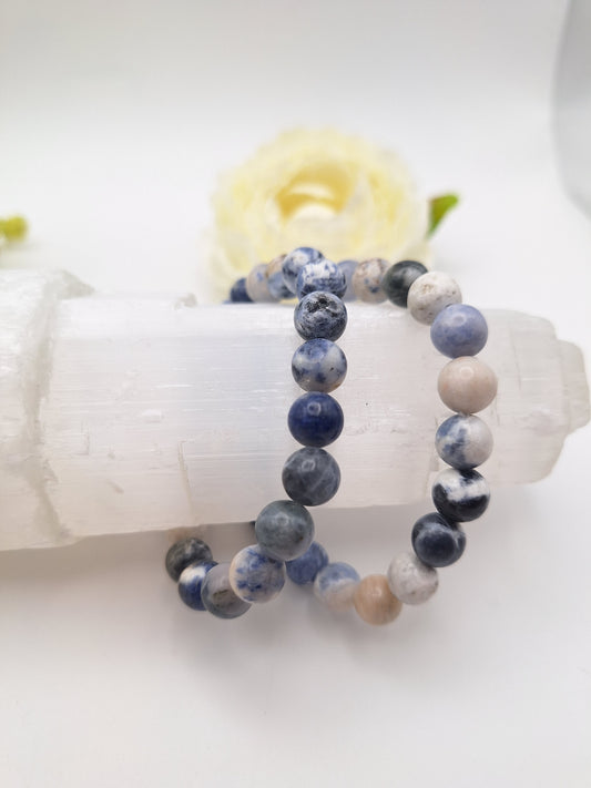 8mm sodalite gemstone bracelet with blue and white marbled beads, designed for intuition, mental strength, and self-expression. Stretchy and unisex, perfect for throat chakra support.
