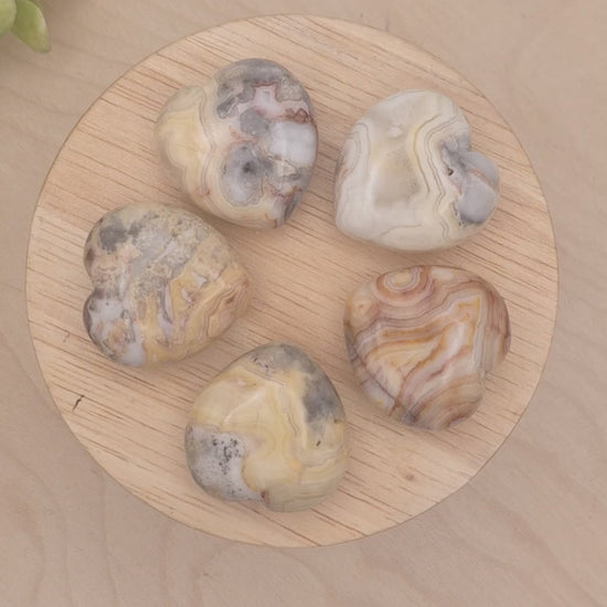 Yellow Crazy Lace Agate hearts on a slowly spinning display showcasing beautiful banding and colors 